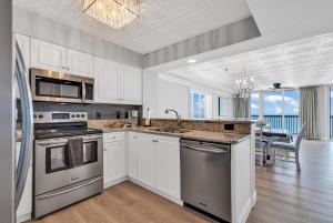 a kitchen with stainless steel appliances and a dining room at 4BR Oceanfront Corner Condo NMB in Myrtle Beach