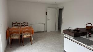 LangenlonsheimにあるBungalow im Parkの部屋にテーブルと椅子のあるキッチン +3枚の写真
