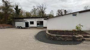 LangenlonsheimにあるBungalow im Parkの白い建物の前に停められたトレーラー