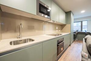 a kitchen with a sink and a microwave at Practical Room For One, Central Nottingham in Nottingham