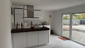 LangenlonsheimにあるBungalow im Parkの白いキャビネットと大きな窓のあるキッチン