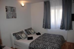 a bedroom with a black and white bed and a window at Room near the center in Split