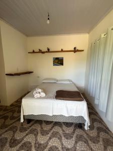 a bedroom with a bed with towels on it at Hospedagem Portal da Terra in São João