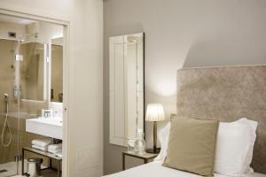 a bedroom with a bed and a sink and a mirror at Hotel Aquarius Venice - Ascend Collection in Venice