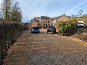 two cars driving down a road in front of a house at L'Air du Pré - loft 5p - Mariomont in Verviers