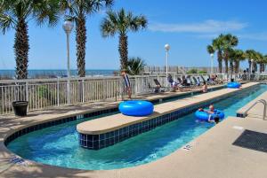 a swimming pool at a resort with people in the water at Crescent Shores North - 502 in Myrtle Beach