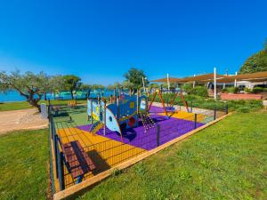 a playground in a park next to the water at Eurocamp Tents at Campsite Polari in Rovinj