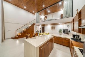 an open kitchen with wooden cabinets and a staircase at Darina - Brand-New Villa Just Minutes from the Beach with a Huge Pool in Badung +2 photos