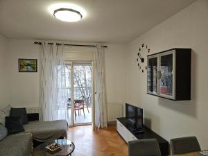 a living room with a couch and a tv at Apartman Judita in Zagreb