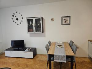 a dining room with a table and a clock on the wall at Apartman Judita in Zagreb +3 photos