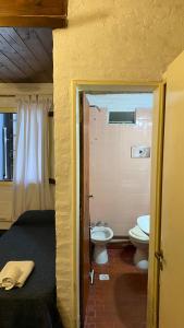 een slaapkamer met een badkamer met een toilet en een wastafel bij Hostería Michel in Villa Gesell