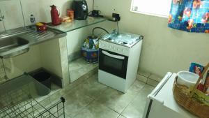 a small kitchen with a stove and a sink at Hospedagem do Marcão in Belo Horizonte