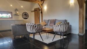 a living room with a couch and a table at Sams Cottage in Roermond