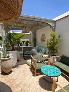 a patio with couches and tables and plants at Riad Bacha Beldi in Marrakech