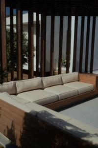 a white couch sitting on top of a balcony at PNOĒS Tinos in Tinos Town