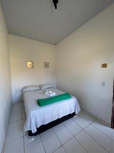 a bedroom with a bed with a green blanket on it at Hospedagem Portal da Terra in São João