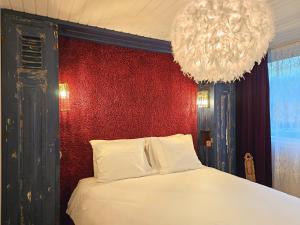 una camera con un letto bianco con una parete rossa di Ferienhaus am Fuße der Dünen! BG05 a Biggekerke