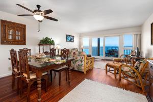 a dining room and living room with a table and chairs at Sea Village 4-205 in Kailua-Kona