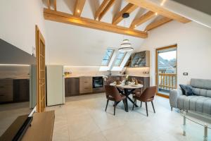 a kitchen and living room with a table and a couch at Apartma pri Hrvatu in Bohinj