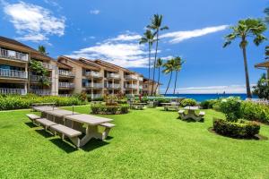 a park with tables and benches in front of a building at Sea Village 4-205 in Kailua-Kona