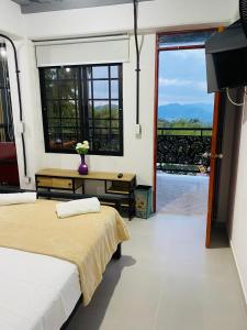 a bedroom with two beds and a large window at Hotel Curazao Natural Living in Cocorná