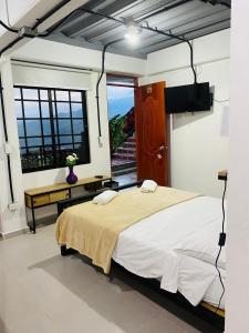 a bedroom with a large bed and a window at Hotel Curazao Natural Living in Cocorná