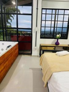 a bedroom with a bed and a bath tub and a window at Hotel Curazao Natural Living in Cocorná +4 photos