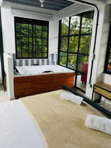 a large bathroom with a tub and a bed at Hotel Curazao Natural Living in Cocorná