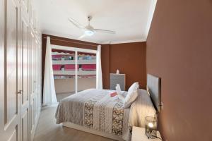 a bedroom with a bed and a ceiling fan at La Casita de Edu in Puerto de Santiago +17 photos