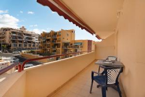a balcony with a table and chairs and buildings at La Casita de Edu in Puerto de Santiago