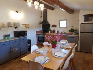 a kitchen with a wooden table with chairs and a dining room at Maison en Luberon in Sainte-Croix-à-Lauze