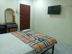 a bedroom with a bed and a flat screen tv at PTT Mansion ปทิตา แมนชั่น in Ban Zong Katiam