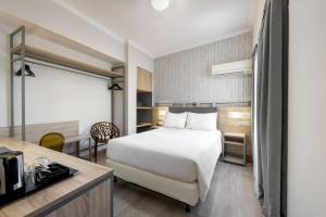 雅典泛酒店的一间配有床和书桌的酒店房间