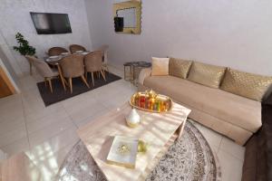a living room with a couch and a table at Cozy Duplex appartement wifi parking proximité in Rabat