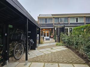 una bicicletta è parcheggiata fuori da una casa di Ferienhaus am Fuße der Dünen! BG05 a Biggekerke