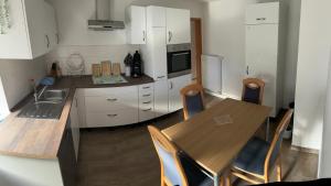 a kitchen with a table and chairs and a refrigerator at Ferienwohnung Aloia in Gammertingen