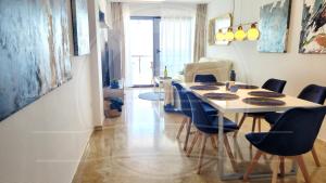 a dining room with a table and blue chairs at Torrevieja4u Front Sea View Apartment in Torrevieja +34 photos