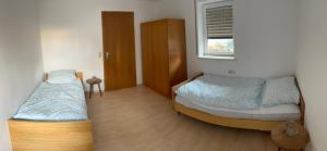 a bedroom with two beds and a window at Ferienwohnung Aloia in Gammertingen