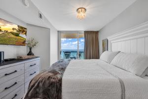 a bedroom with a bed and a view of the ocean at 4BR Oceanfront Corner Condo NMB in Myrtle Beach
