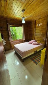Un dormitorio con una cama en una habitación de madera. en Recanto da Tia Juju, en Santa Teresa