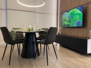 a dining room with a table with chairs and a tv at Garibaldi Suite 2 Renovated 1BR with Parking, Old Town Olbia in Olbia