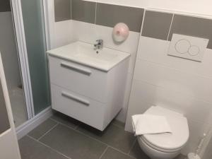 La salle de bains est pourvue d'un lavabo blanc et de toilettes. dans l'établissement Le Relais de Monti, à Menton