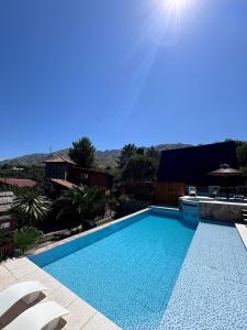 a large swimming pool with two chairs and the sun at A Mi Manera Apart in Merlo