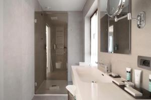 a bathroom with a sink and a mirror and a shower at Hotel Aquarius Venice - Ascend Collection in Venice