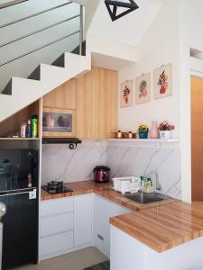 a kitchen with white cabinets and a staircase at Villa Neona Nora in Tlekung