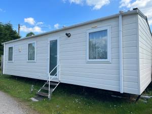 a white tiny house with a ladder at New Forest Hideaway- Self Catering Accommodation in Newbridge