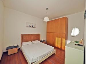 a bedroom with a bed and a wooden cabinet at Finestra Sul Mare in San Terenzo