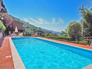 a large blue swimming pool with mountains in the background at Finestra Sul Mare in San Terenzo
