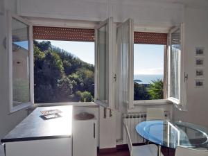 a kitchen with a table and two large windows at Finestra Sul Mare in San Terenzo