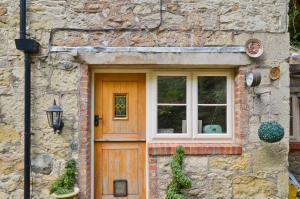 a brick house with a wooden door and a window at 1 Apse Castle Cottage - Chocolate Box Cottage, Pet-Friendly 16th Century Cottage, surrounded by Ancient Woodland in Shanklin in Shanklin